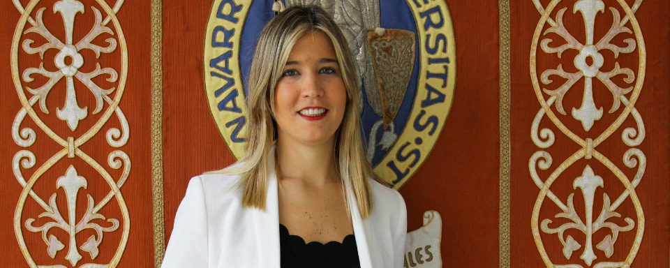 Sofía Teixeira frente al escudo de la Universidad de Navarra.