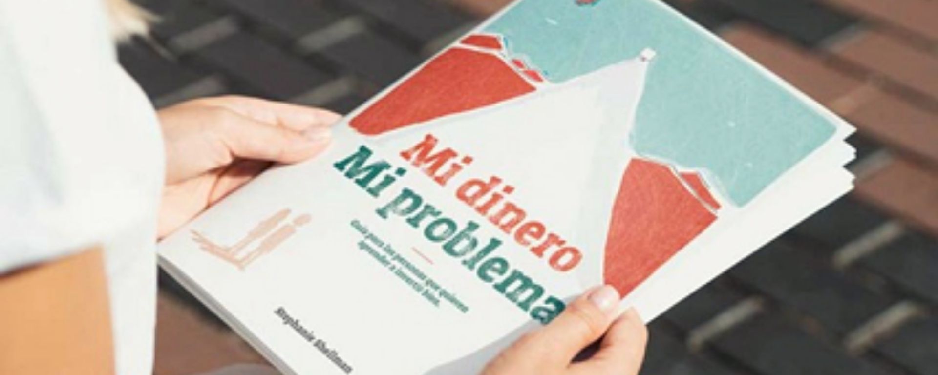 Manos sosteniendo el libro "Mi dinero. Mi problema"