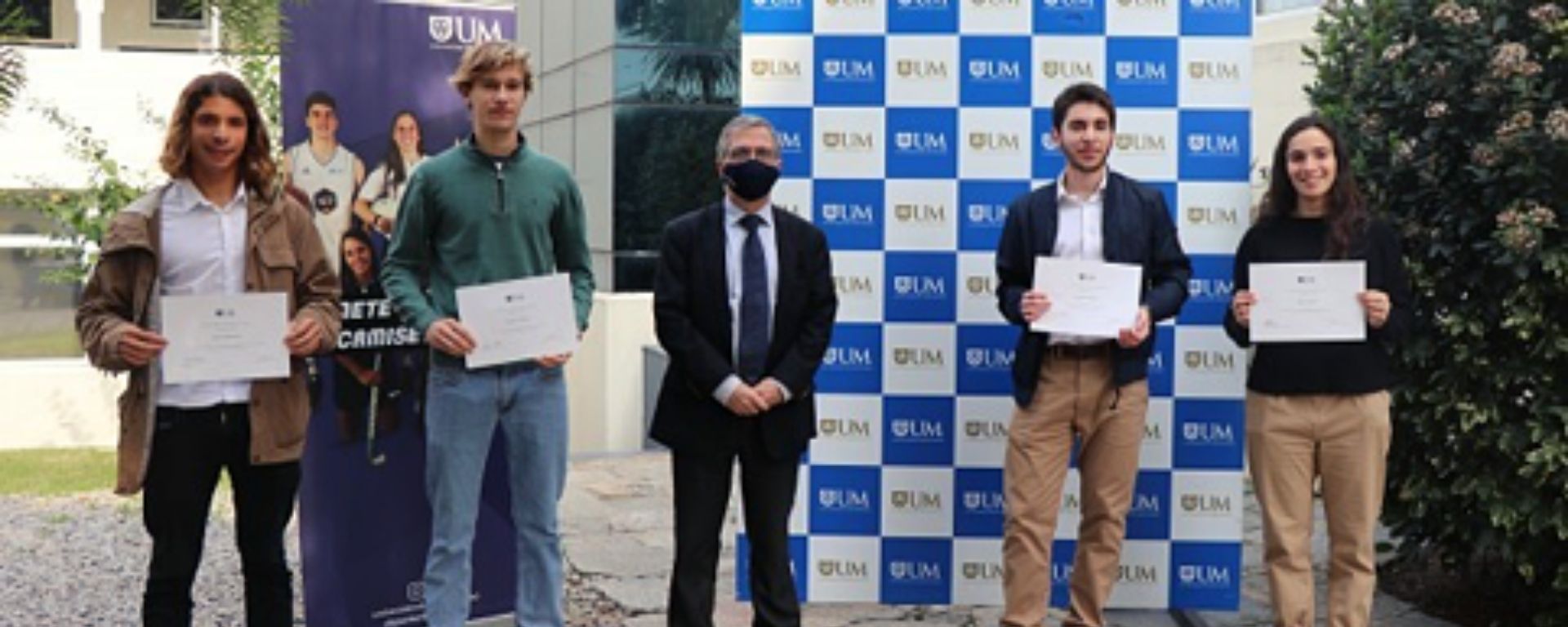 Cuatro alumnos becados junto al representante de la UM