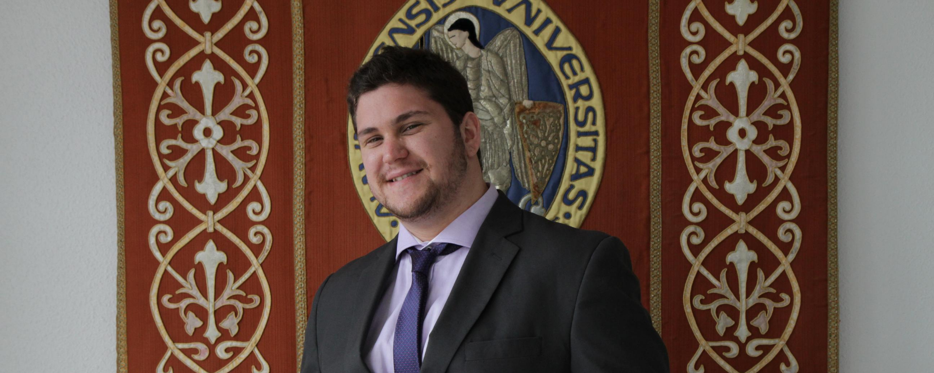 Daniel Jurburg frente al escudo de la Universidad de Navarra.