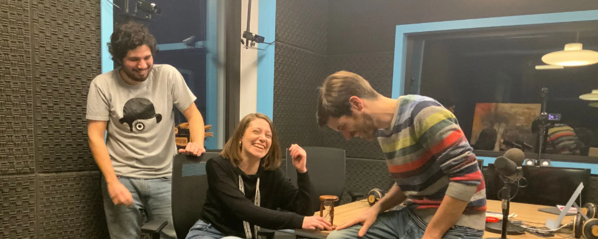 Los tres graduados de la UM ríen dentro de un estudio de radio.