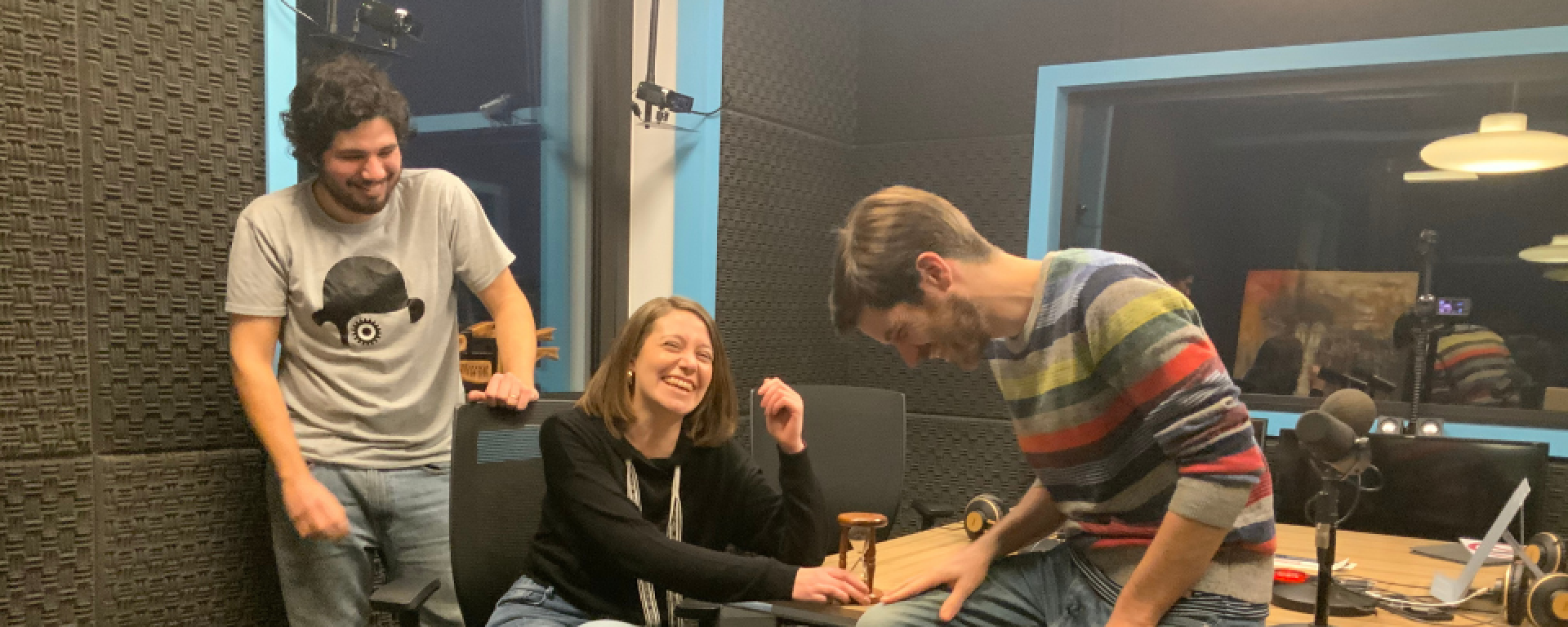 Los tres graduados de la UM ríen dentro de un estudio de radio.