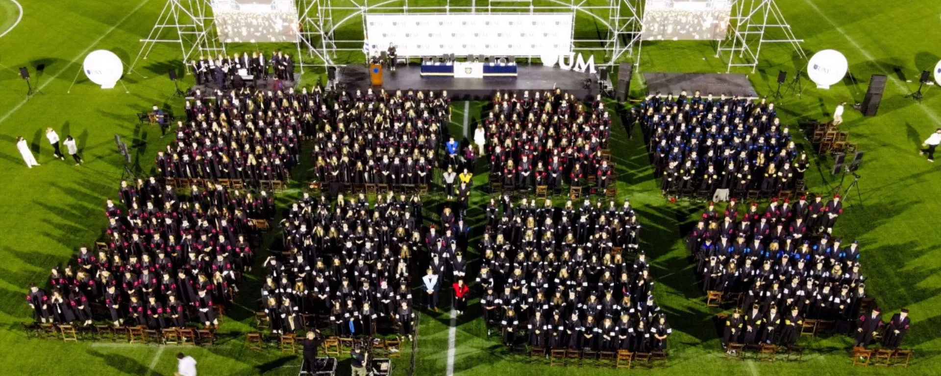 Imagen aérea de los graduandos durante la ceremonia en el Estadio Charrúa. Imagen aérea de muchos jóvenes con toga y birrete.