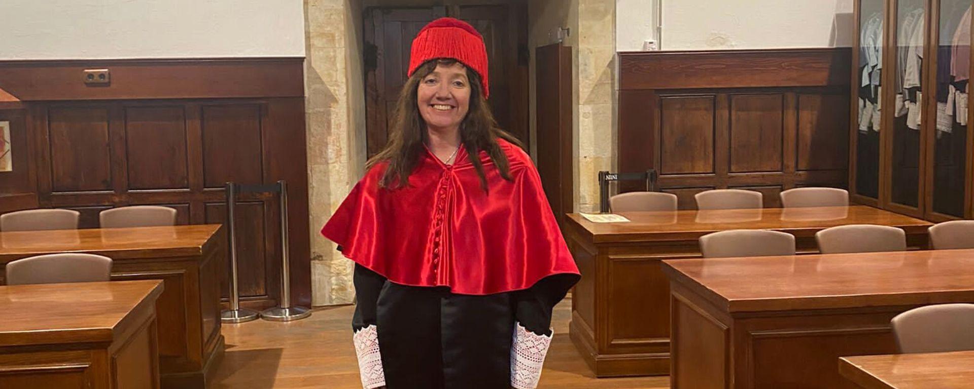 Andrea Signorino recibió título de doctorado con honores Andrea Signorino vestida de toga negra, y birrete y capa color rojo